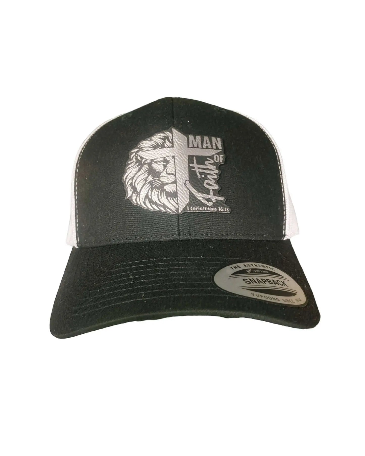 A black leather patch trucker hat engraved with "Man of Faith" and "1 Corinthians 16:13" wording overlaid with a lion and cross with white mesh on the back half of the hat, all set on a white background.