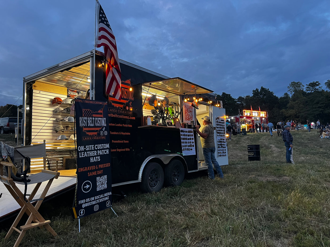 Rust Belt Customz mobile engraving trailer with hats displayed outside in Northeast Ohio.