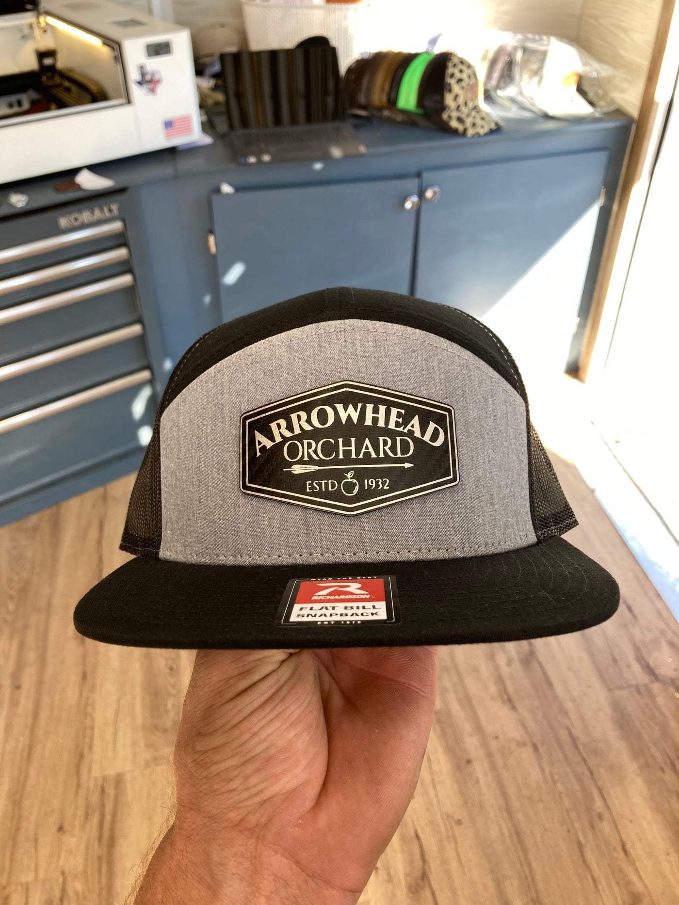 Close view of a finished custom leatherette patch on a Richardson 168 hat in the Rust Belt Customz workshop.