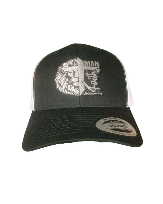 A black leather patch trucker hat engraved with "Man of Faith" and "1 Corinthians 16:13" wording overlaid with a lion and cross with white mesh on the back half of the hat, all set on a white background.